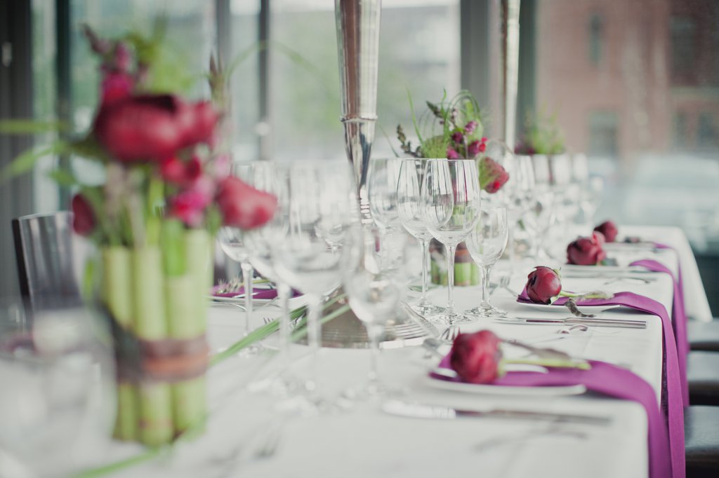Photo Festtafel mit dunkelroten Pfingstrosen und grünem Baumbus.