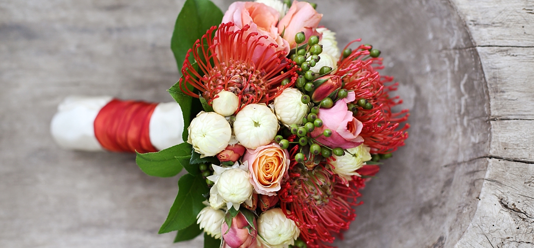 Brautstrauß mit Rosen und Protea in burnt orange, rosa und weiß